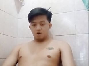 Young Asian guy in the bathroom pissing and jerking off