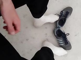 a young skater shows off his white socks and sneakers